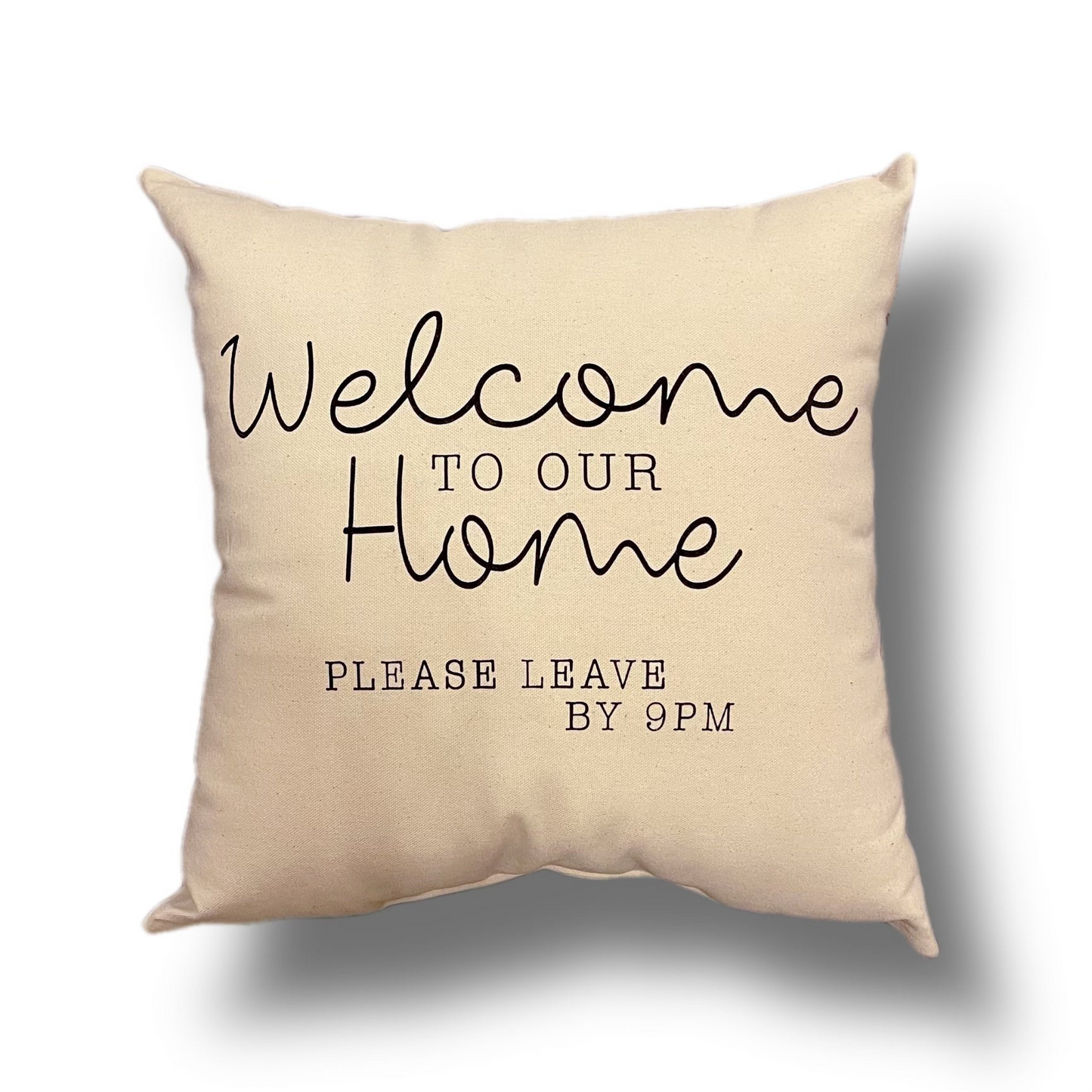Light beige pillow that says "welcome to our home please leave by 9PM" on a white background