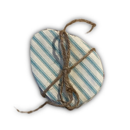 A bundle of striped fabric easter eggs tied together with twine, on white background.